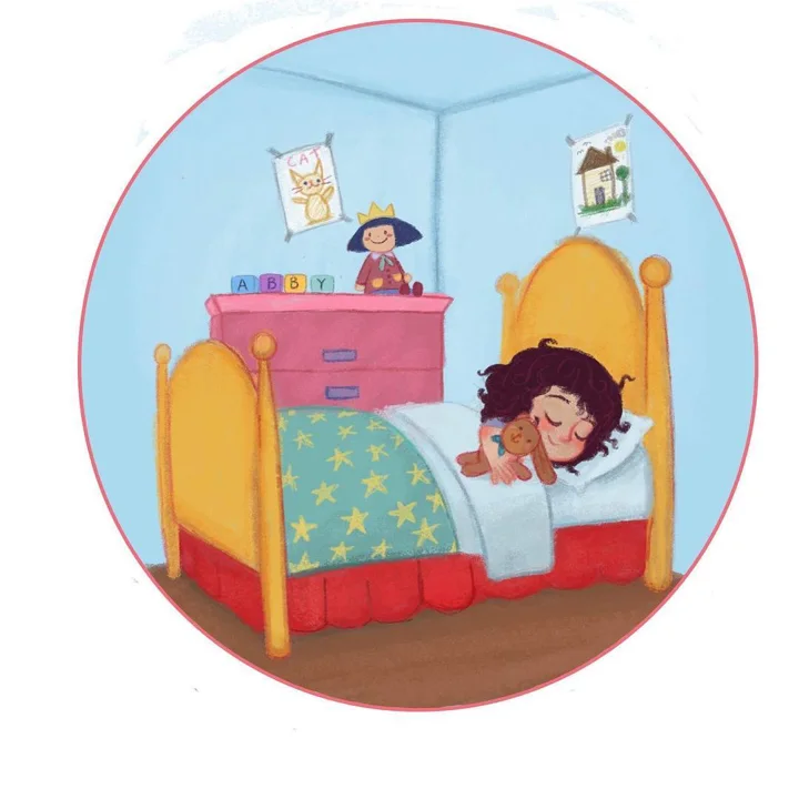 Digital illustration in a circle of a curly-haired girl asleep in a yellow bed with a teddy bear, by blocks spelling ABBY.