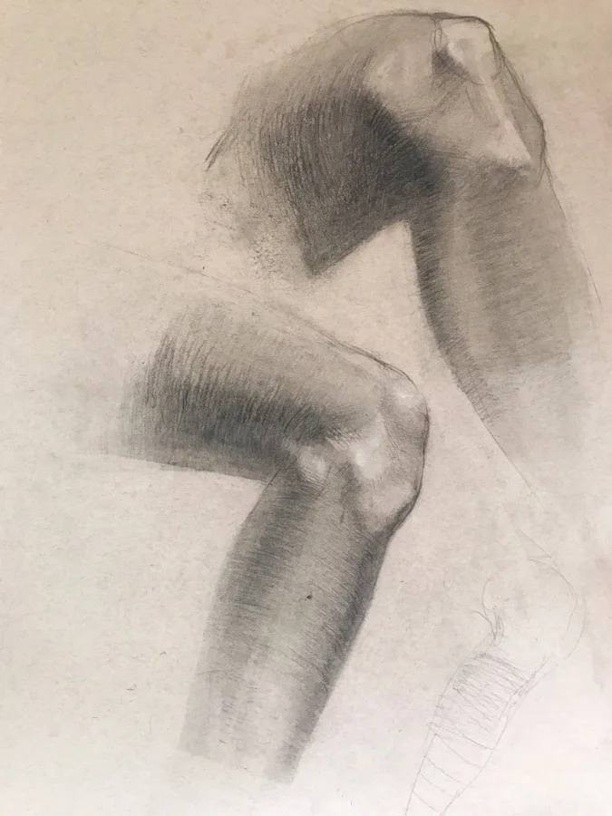 Charcoal figure study of a bent knee and limbs in soft gray tones on cream paper.