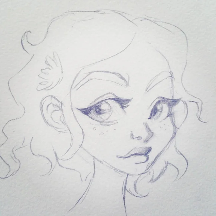 Pencil and blue ballpoint sketch of a freckled girl with curly hair, winged eyeliner, and full lips.