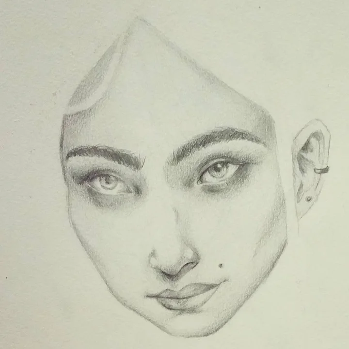 Pencil study of a young woman's face with strong brows, a beauty mark, and a pierced ear.