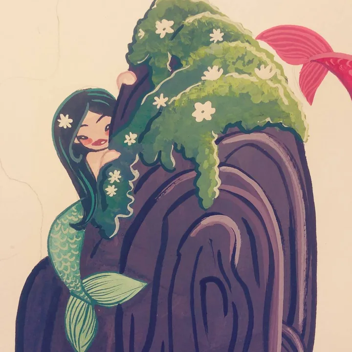 Gouache painting of a dark-haired mermaid with a green tail hugging a tall dark rock topped with moss and white flowers.